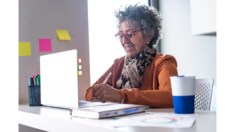 Older latin woman works from her home desk