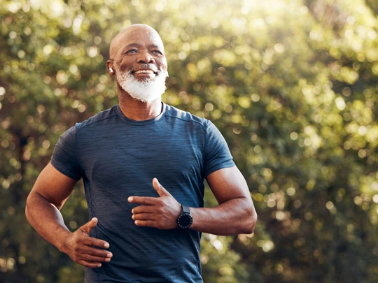A fit man jogging during a nice spring day smiling. - For retirement planning